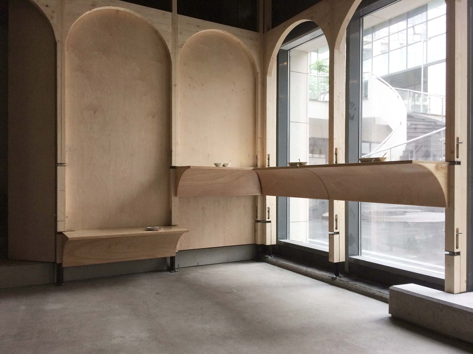 Vedere din interiorul localului cu mese în consolă montate la înălțimi diferite