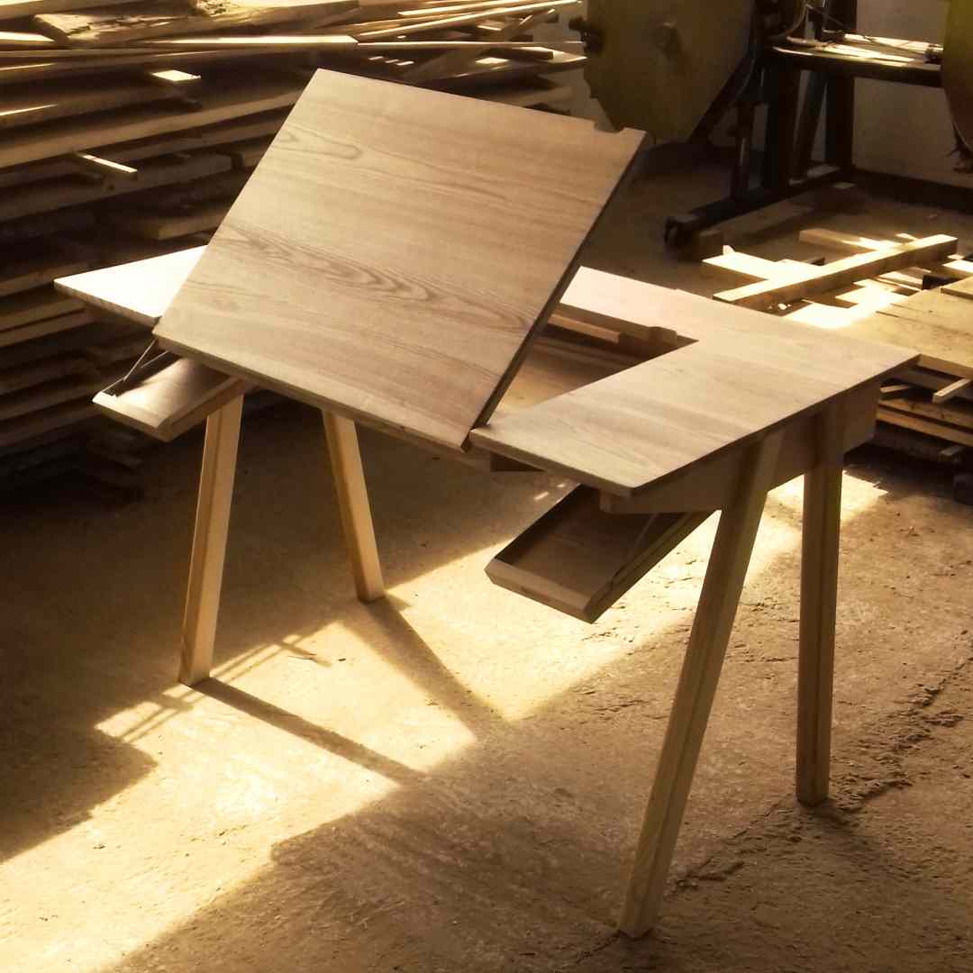 vedere din atelierul de tâmplarie cu birou din lemn de frasin cu blat înclinabil rabatat și uși cu limitatoare de coborâre