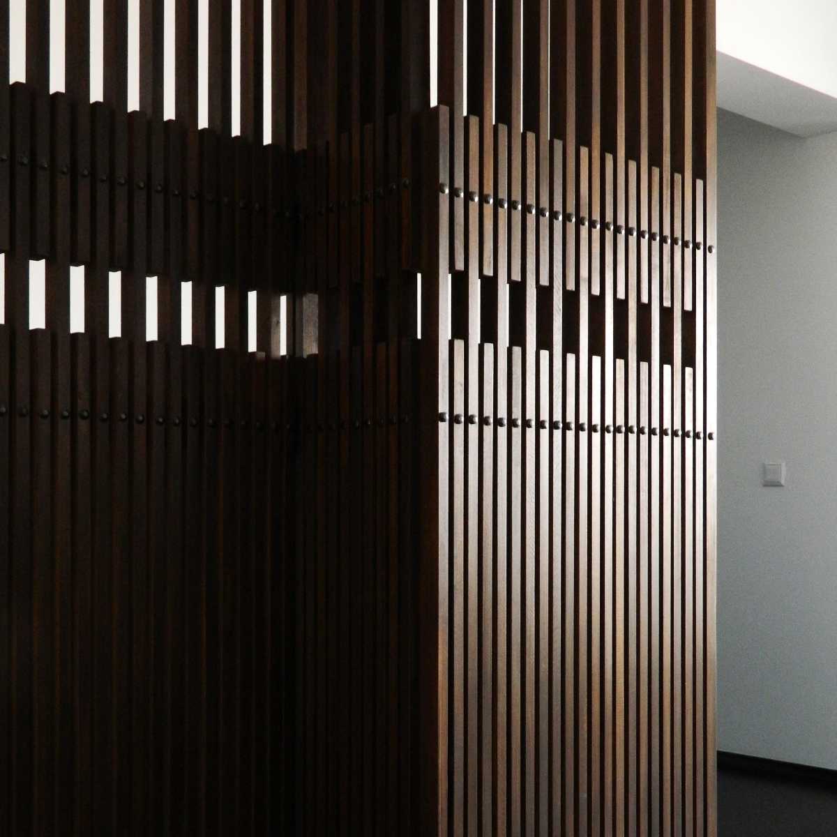 Paravan separator cu perforații rezultate din dispunerea alternantă a șipcilor de lemn