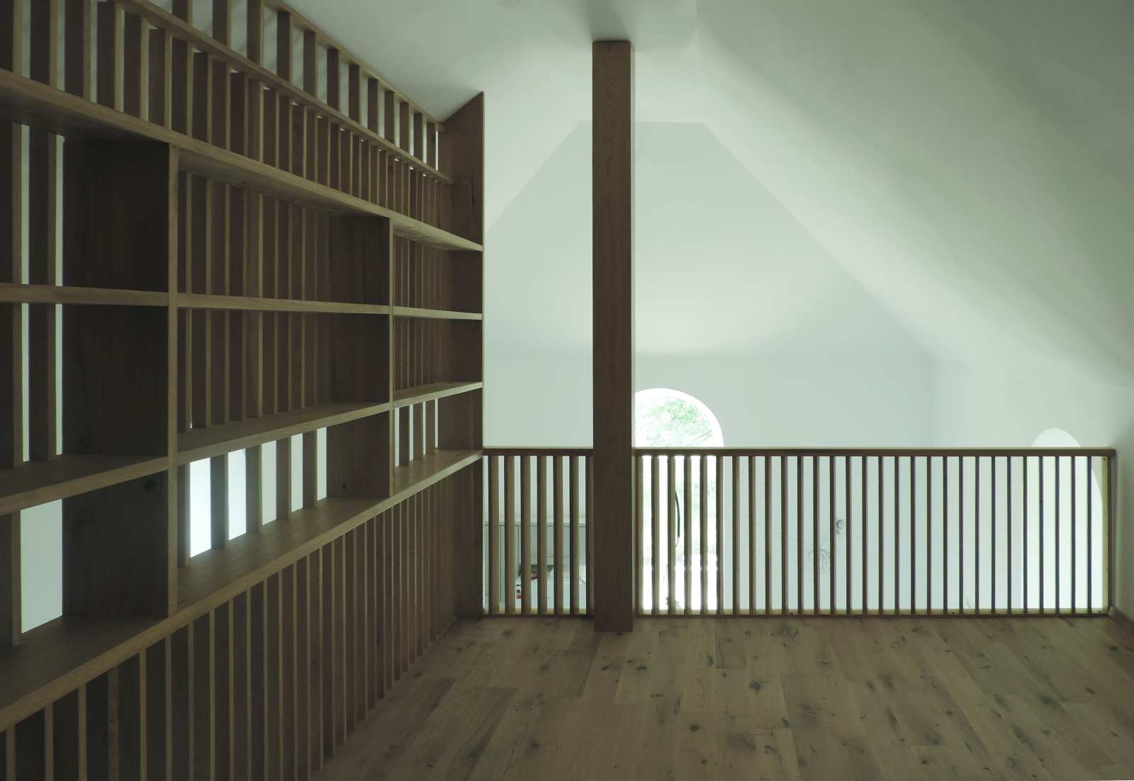 Vedere din spațiul mansardei cu balustrada din lemn și peretele separator