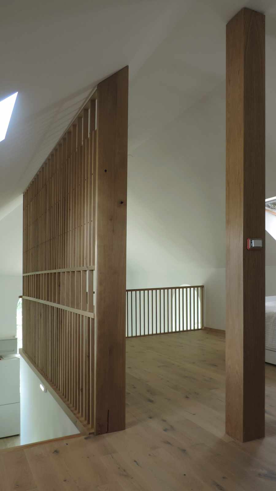 Vedere cu spațiul de la mansardă cu stâlpii de lemn în prim plan