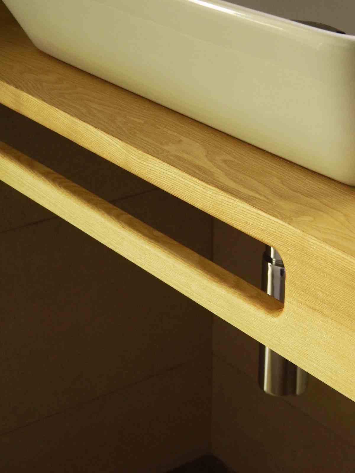 detaliu cu suport de prosoape decupat în frontul blatului pentru chiuvetă cu sifon cromat