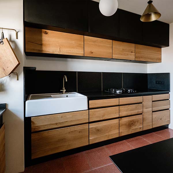 Bucătărie cu dulapuri negre și uși din lemn de stejar natur